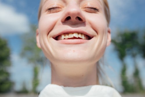 young smiling woman with crooked teeth