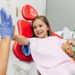 child high-fives hygienist